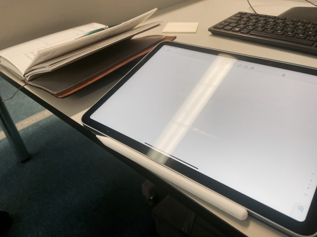Notebook next to an Ipad
